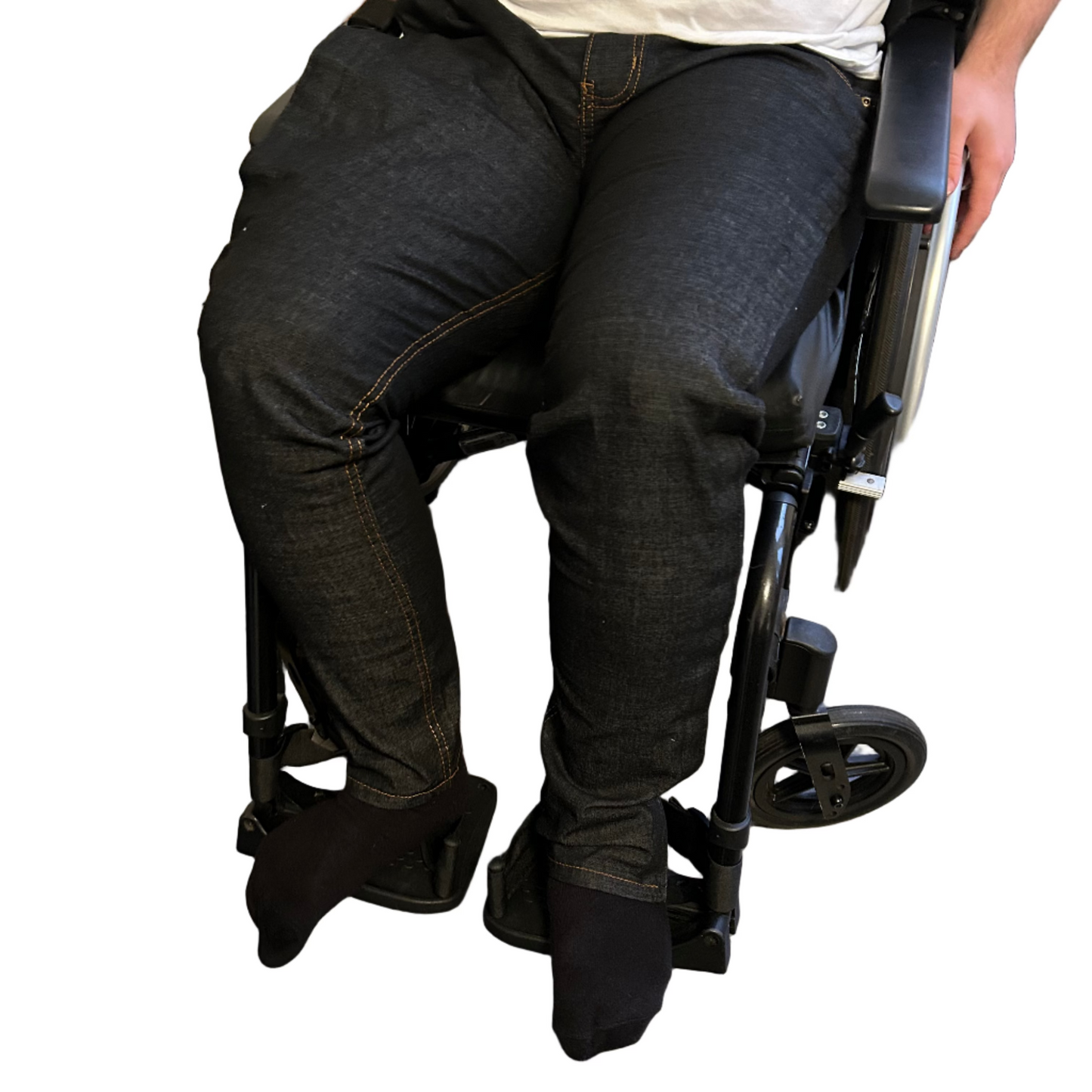 Person using a wheelchair indoors on a wooden floor.
