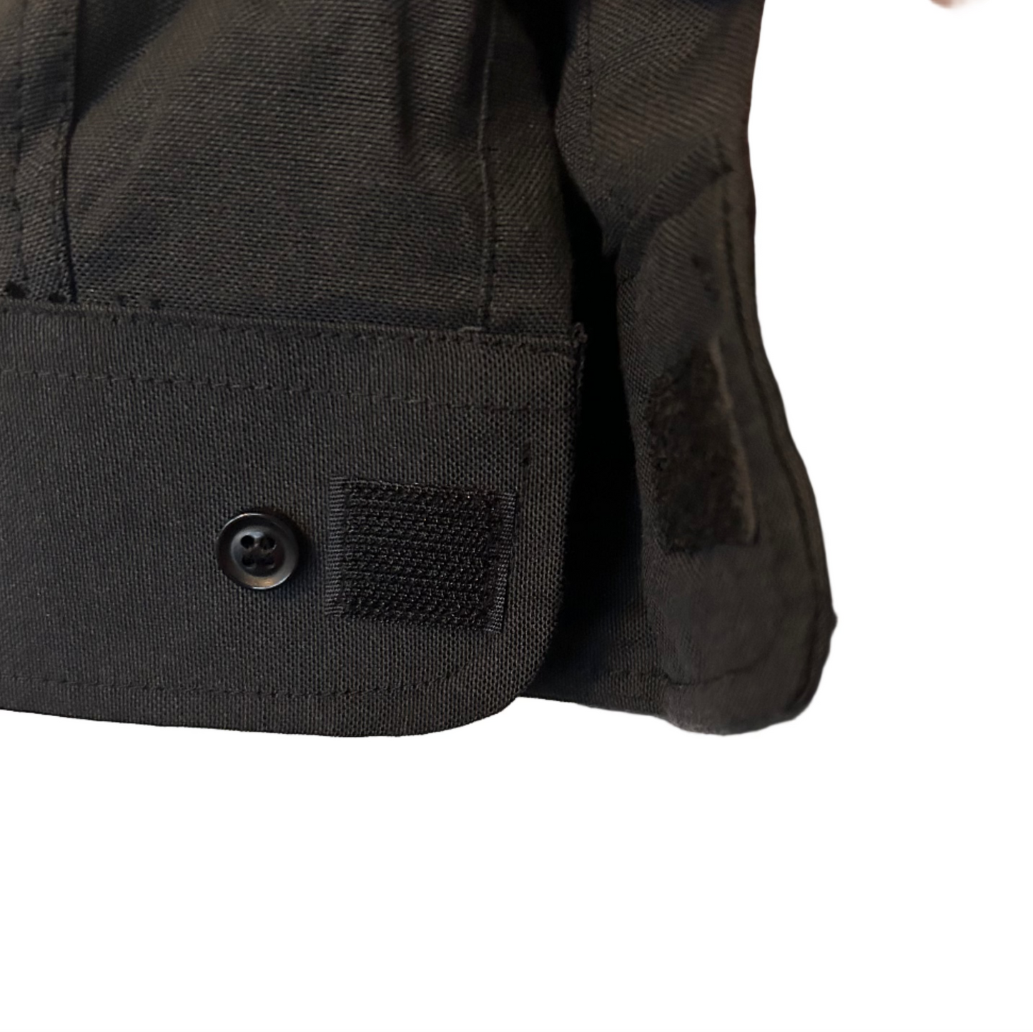 Close-up of a black jacket with a button and patch on a white background