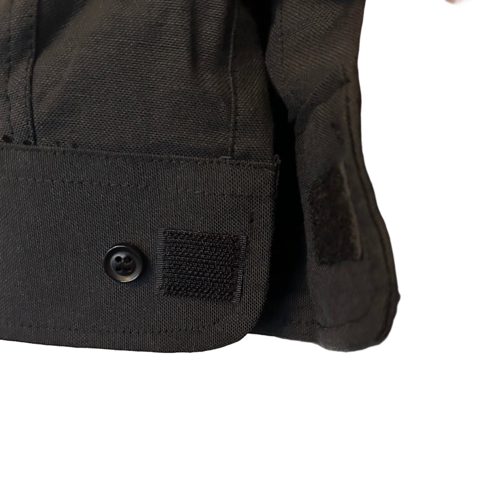 Close-up of a black jacket with a button and patch on a white background