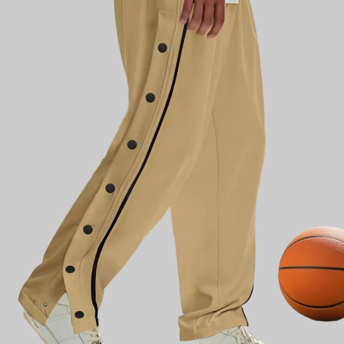 Person wearing beige pants with black buttons on a basketball court