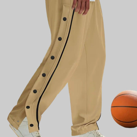 Person wearing beige pants with black buttons on a basketball court